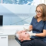 Man undergoing oral cancer screening at dentist